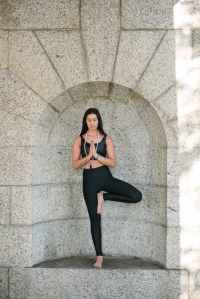 woman in black tank top and black leggings standing near wall